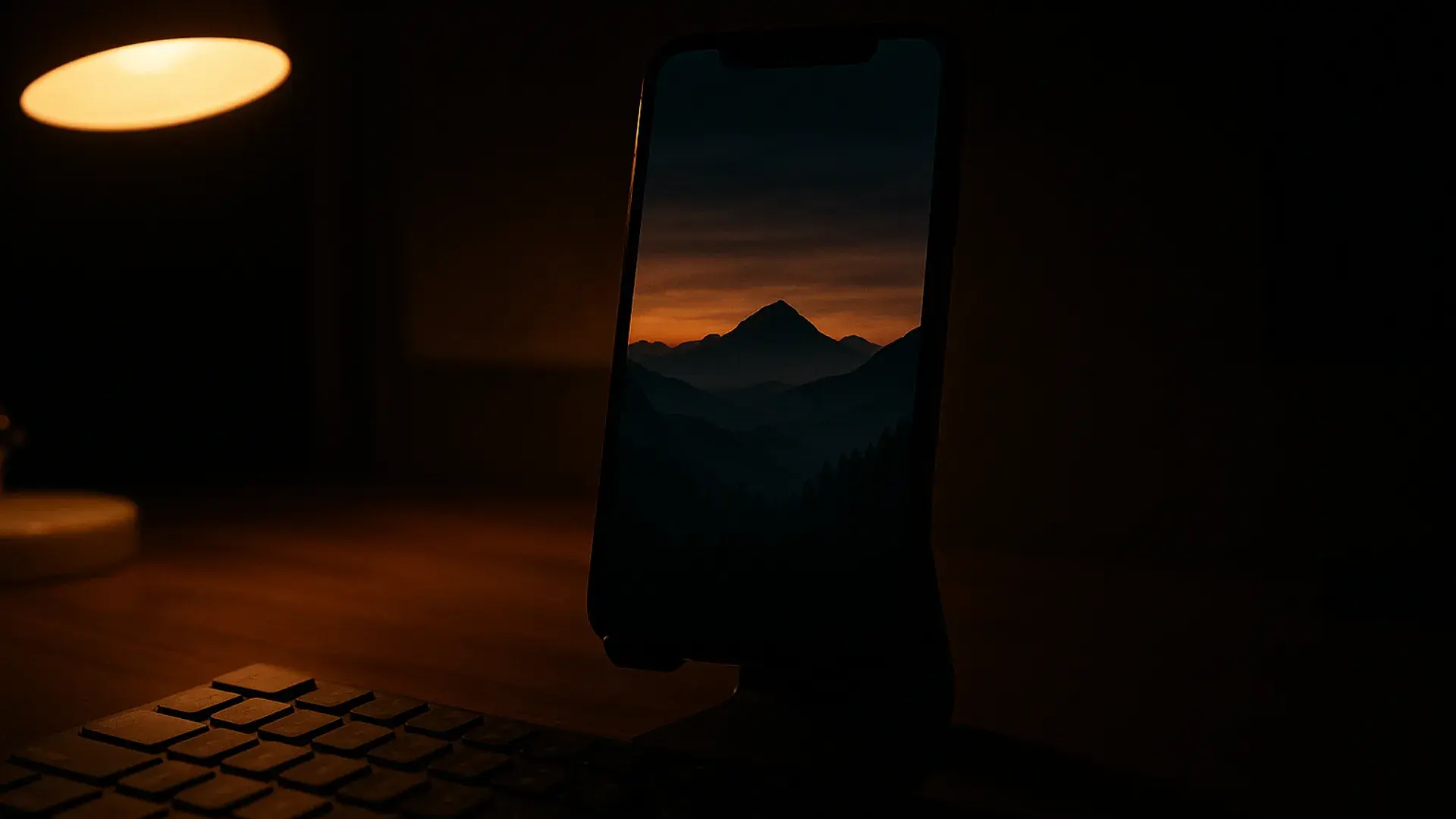 Faceless reel of a moody mountain landscape playing vertically on a phone in a dark workspace